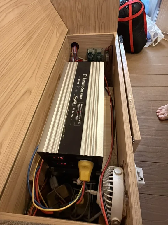 座椅收納空間內的大型銀色 6000W 逆變器，外觀看起來像大型變壓器