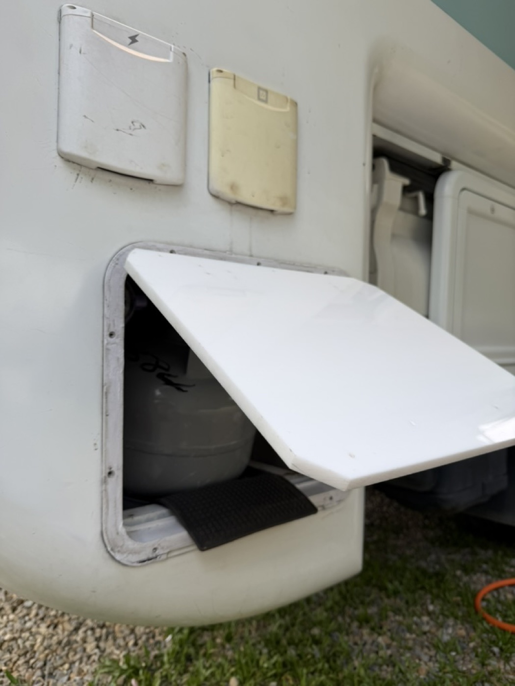 Taipei campervan right rear compartment open showing LP tank and lines—check only if hot water or stove issues arise.