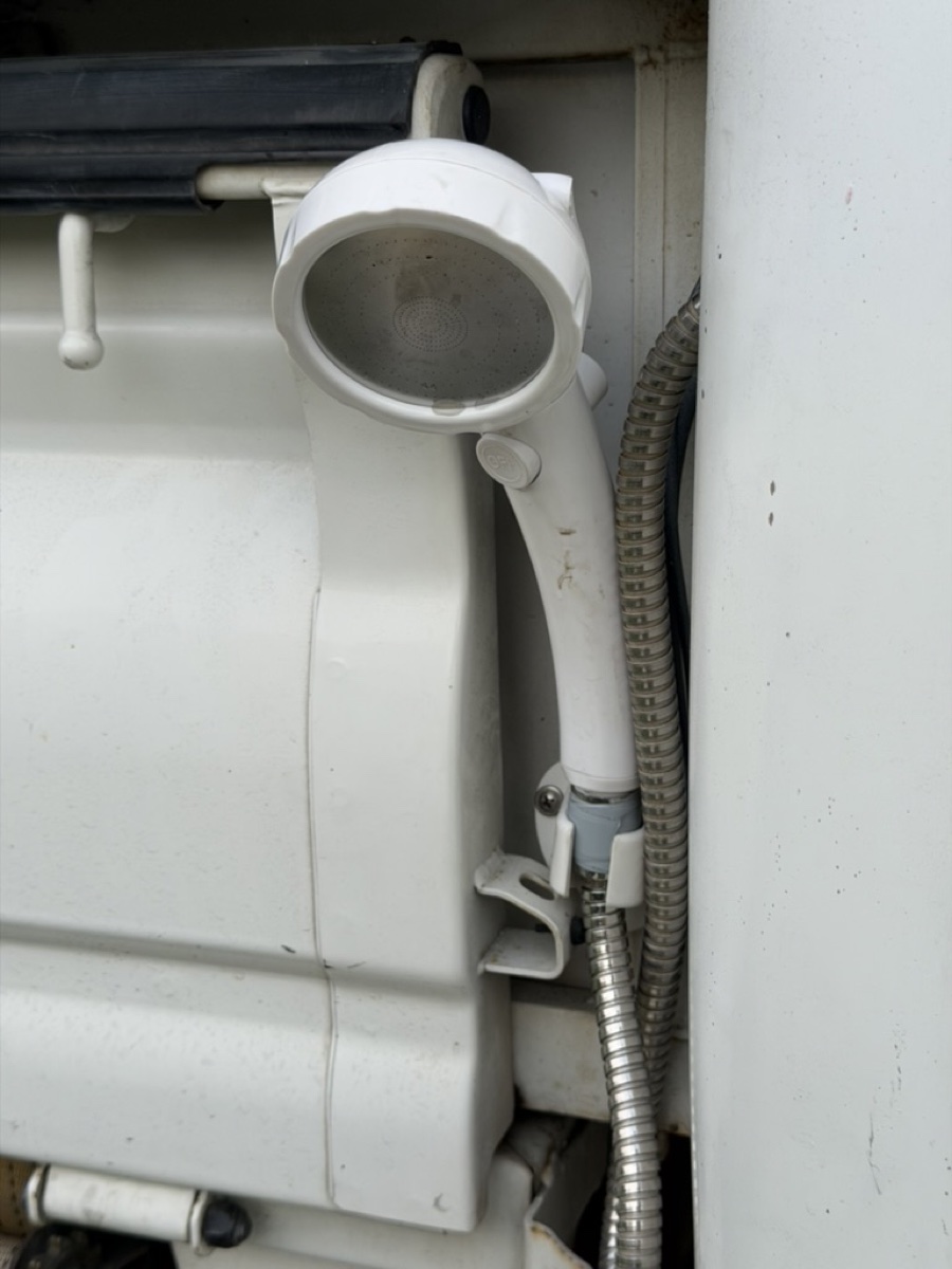 Taipei campervan left rear white rinse shower head on corrugated hose—for feet, sand or pets after the beach.
