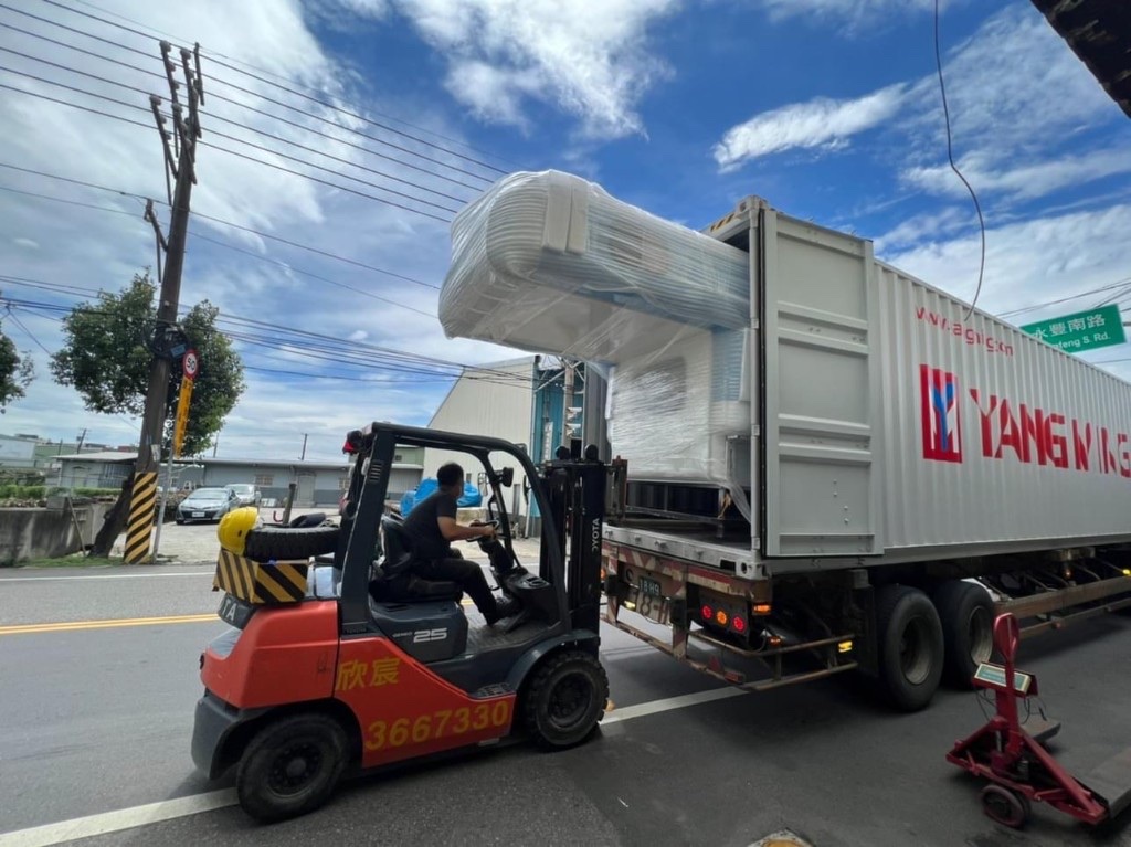 揪好森露營車夢想執行紀錄：堆高機自海運貨櫃卸下包裝完整的露營車體組件，戶外卸貨現場藍天白雲